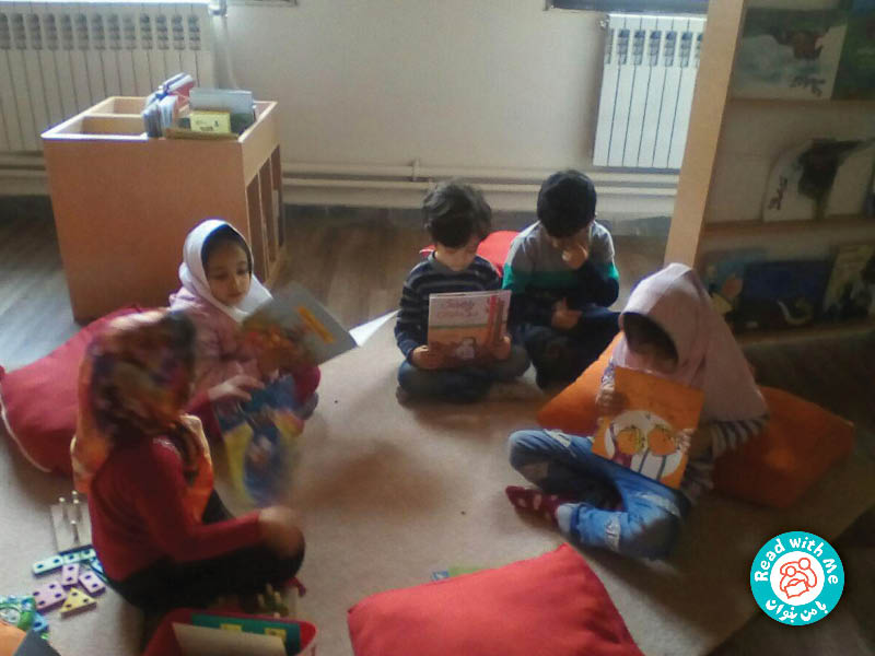کودکان جلد کتاب‌ها را تصویرخوانی می‎کنند.